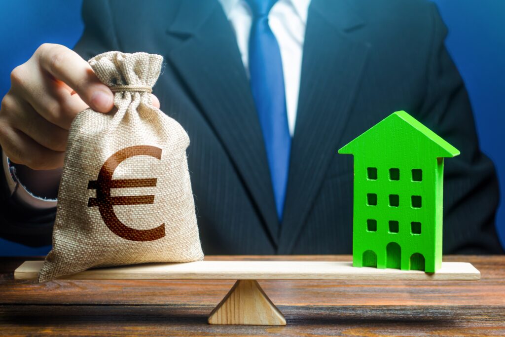 Businessman,Puts,Euro,Money,Bag,On,Scales,And,Green,House.