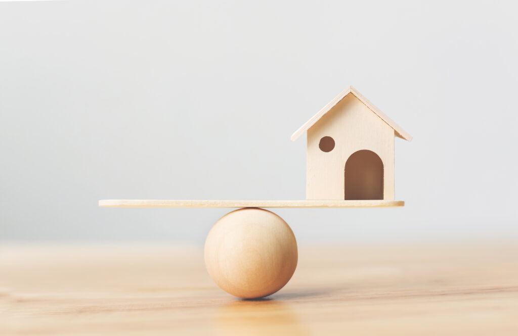 Wooden,Home,On,Wood,Scale,Seesaw.,Property,Investment,And,House